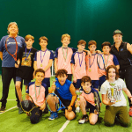 Giovani tennisti con medaglie e trofei sul campo.