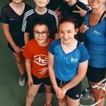 Gruppo di giovani tennisti con allenatrice.